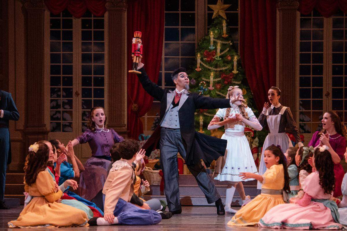 Charlotte Ballet dancer Andrès Trezevant plays Drosselmeyer, holding the nutcracker aloft, in a performance of “Nutcracker.” Trezevant was recently promoted from Charlotte Ballet II, a two-year pre-professional training program, to the main company. Trezevant played Drosselmeyer while a member of Charlotte Ballet II.
