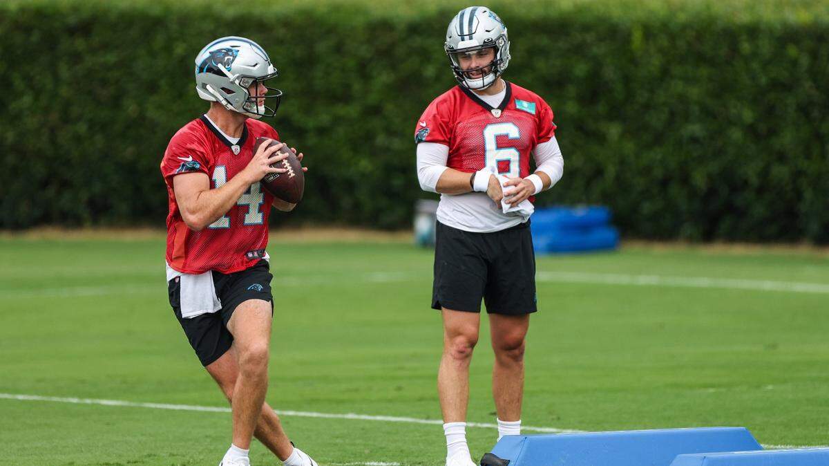 Panthers quarterback Sam Darnold, left, runs through a drill as fellow quarterback, Baker Mayfield, watches during the Back Together practice in Gibbs Stadium at Wofford College on Saturday, July 30, 2022 in Spartanburg, SC.