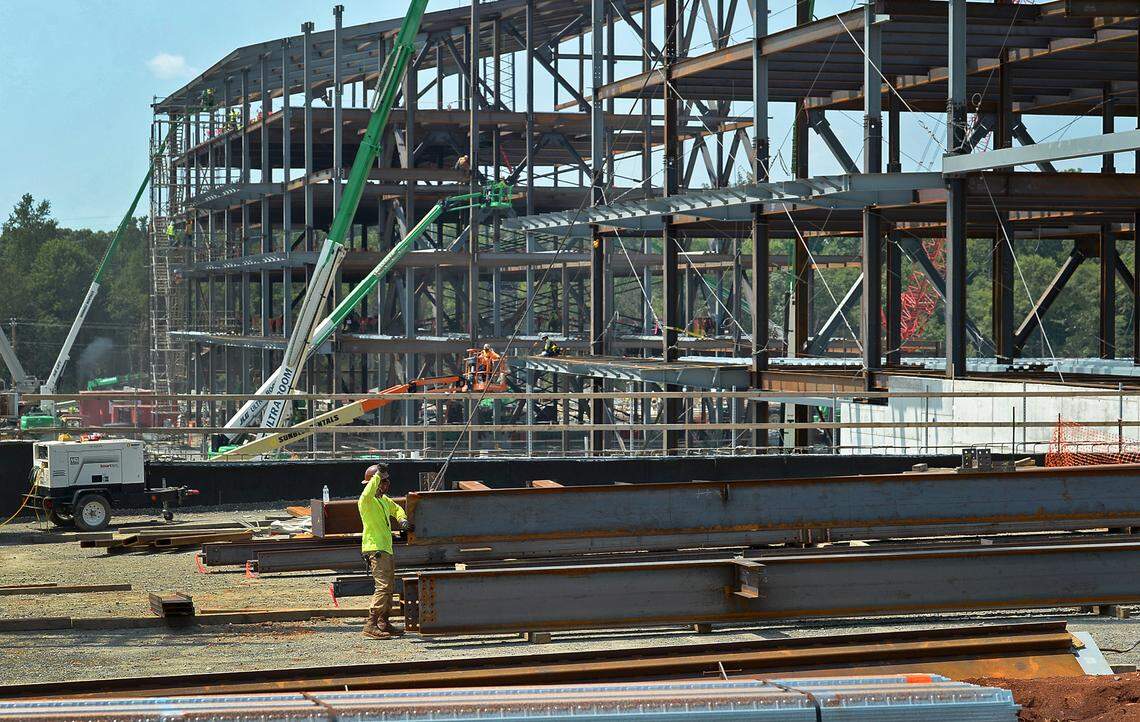 A worker motions for a piece of steel to be moved at the Carolina Panthers new football operations and training in Rock Hill, SC on Monday, August 23, 2021.