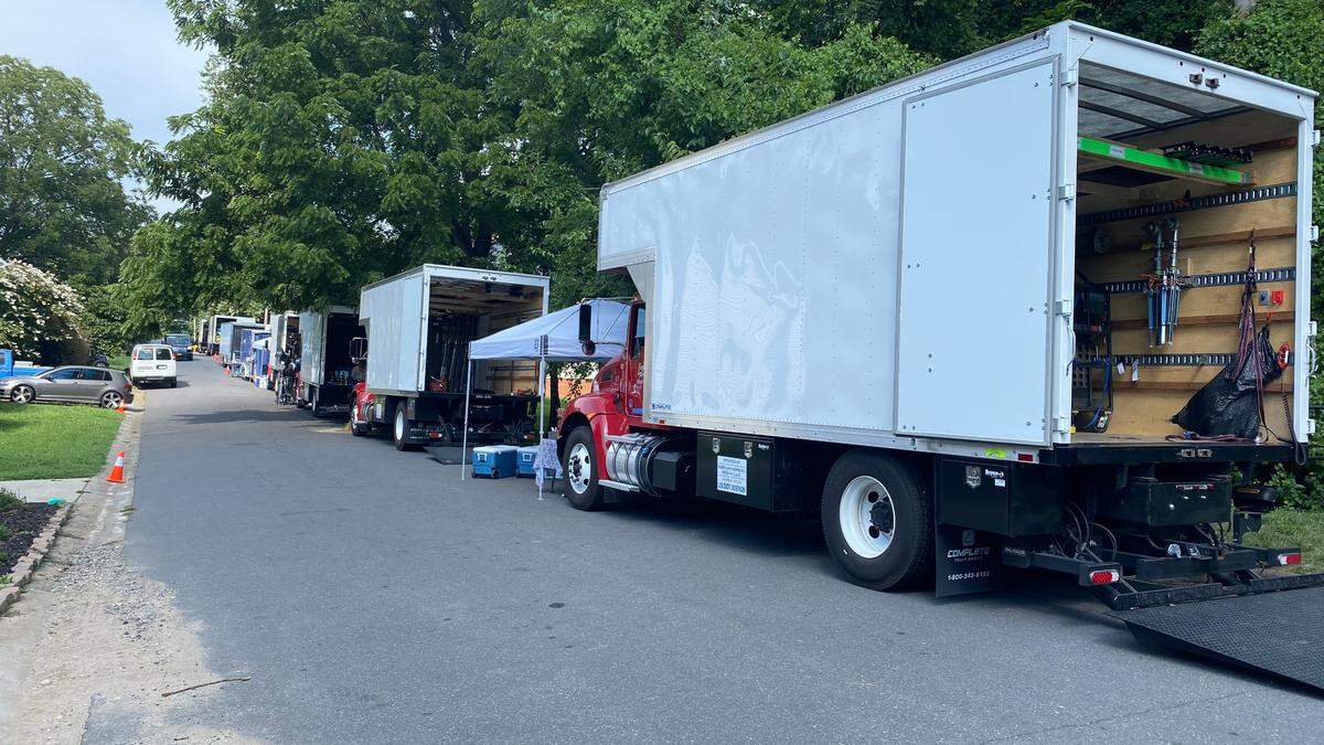Trucks line a street in NoDa during filming of “Please Don’t Destroy: The Treasure of Foggy Mountain” in 2022.