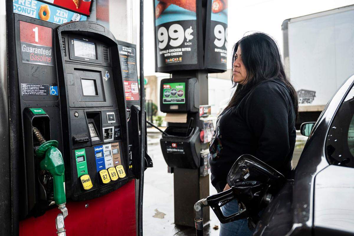 Saira Montesinos watches the screen as as she pumps gas at the QuikTrip on North Graham Street on Wednesday, March 9, 2022 in Charlotte, NC. Montesinos is the manager at La Caseta, a restaurant in Camp North End, and regularly has to use her car to buy supplies for the business. “I try to make less trips, but it depends on what the business needs.”