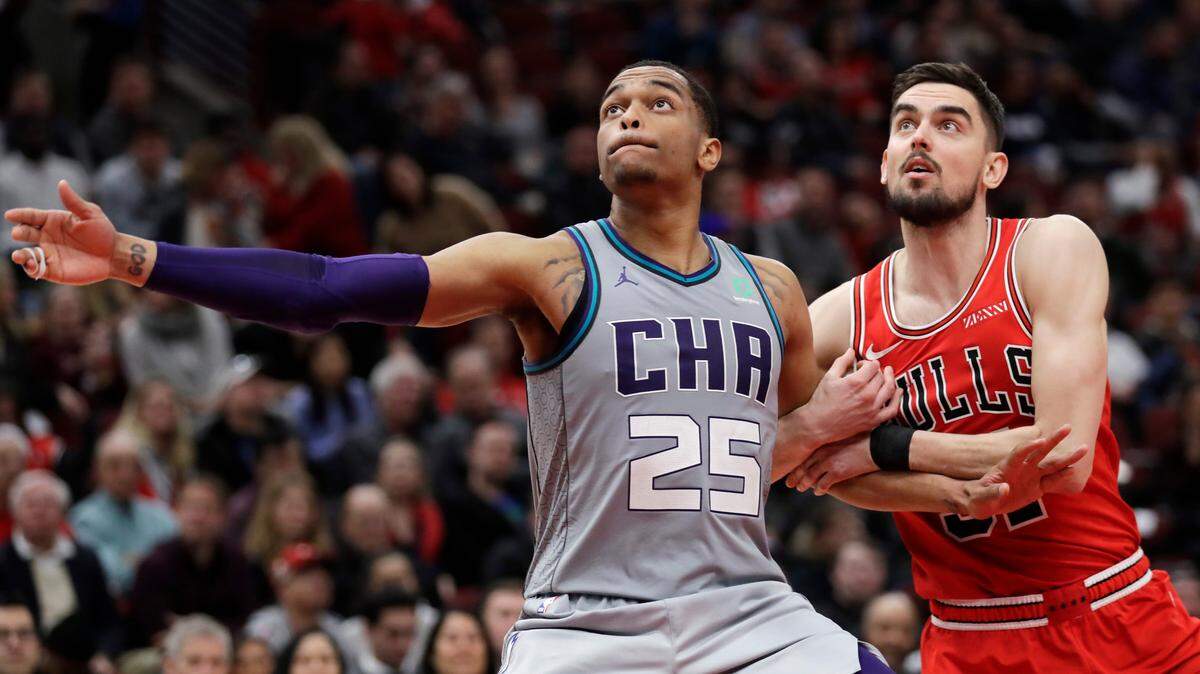Charlotte Hornets forward P.J. Washington, left, and Chicago Bulls guard Tomas Satoransky battle for a rebound during the second half of an NBA basketball game Friday, Dec. 13, 2019, in Chicago. (AP Photo/Nam Y. Huh)