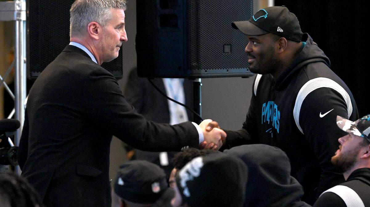 New Carolina Panthers head coach Frank Reich, left, meets with offensive tackle Taylor Moton, right, during Reich’s introductory press conference at Bank of America Stadium on Tuesday, January 31, 2023.