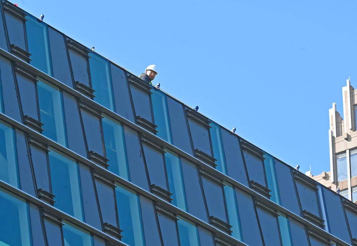 A construction worker looks down from the roof of Charlotte Mecklenburg Library’s new Main Library on North Tryon Street.