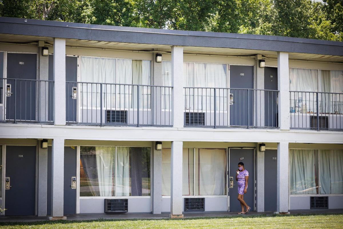 A resident walks along a sidewalk at the Southern Comfort Inn in Charlotte, N.C., Thursday, June 2, 2022. The Southern Comfort Inn is closing at the end of June forcing out roughly 80 households.