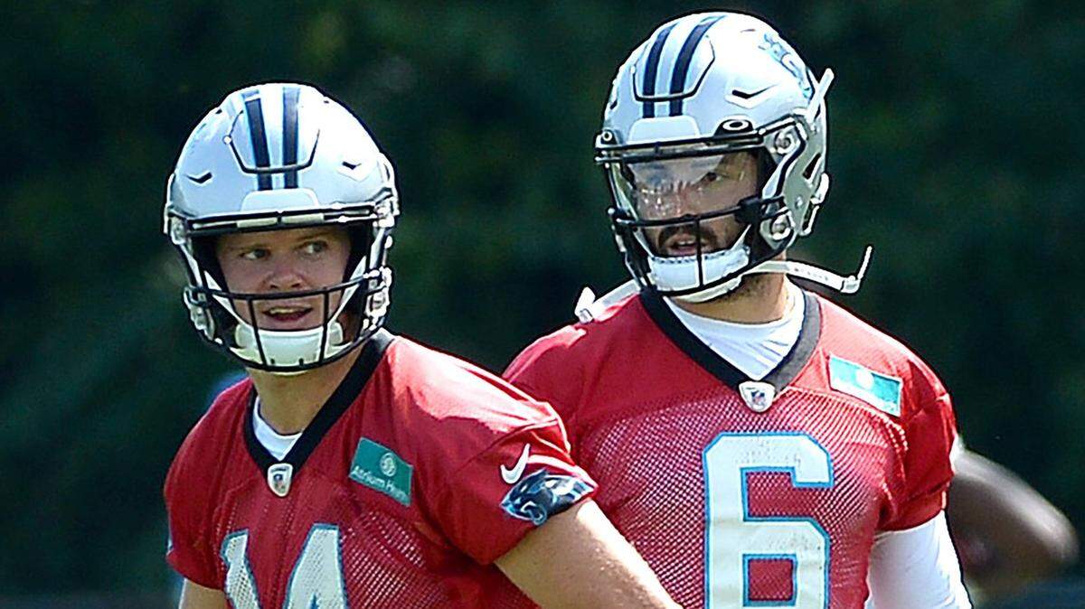 Carolina Panthers quarterback Sam Darnold, left, jogs off to begin drills as quarterback Baker Mayfield, right, looks on. The Panthers held their first training camp practice on Wednesday, July 27, 2022 at Wofford College in Spartanburg, SC.