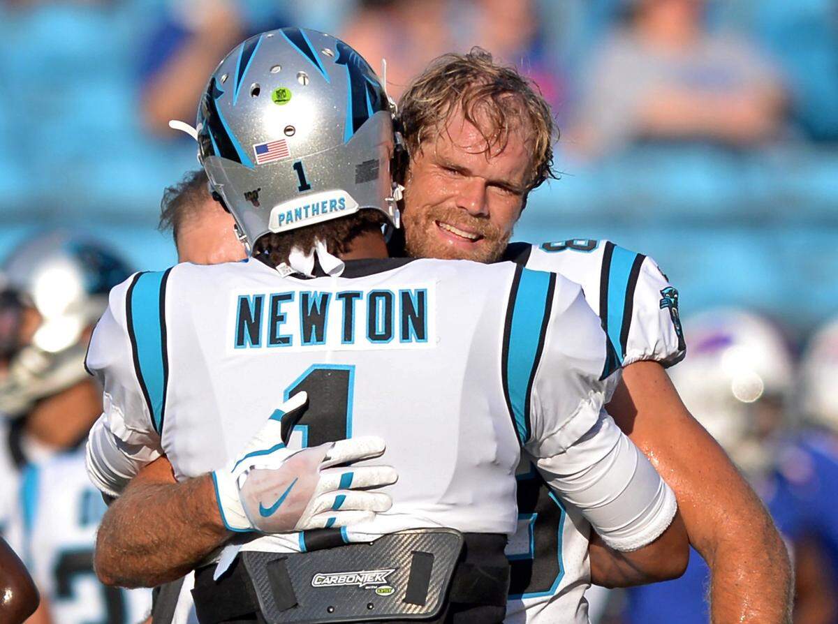 Carolina Panthers tight end Greg Olsen smiles as he is hugged by quarterback Cam Newton in 2019. Since the two men left the Panthers, the team hasn’t been able to find consistent production at either of their positions.