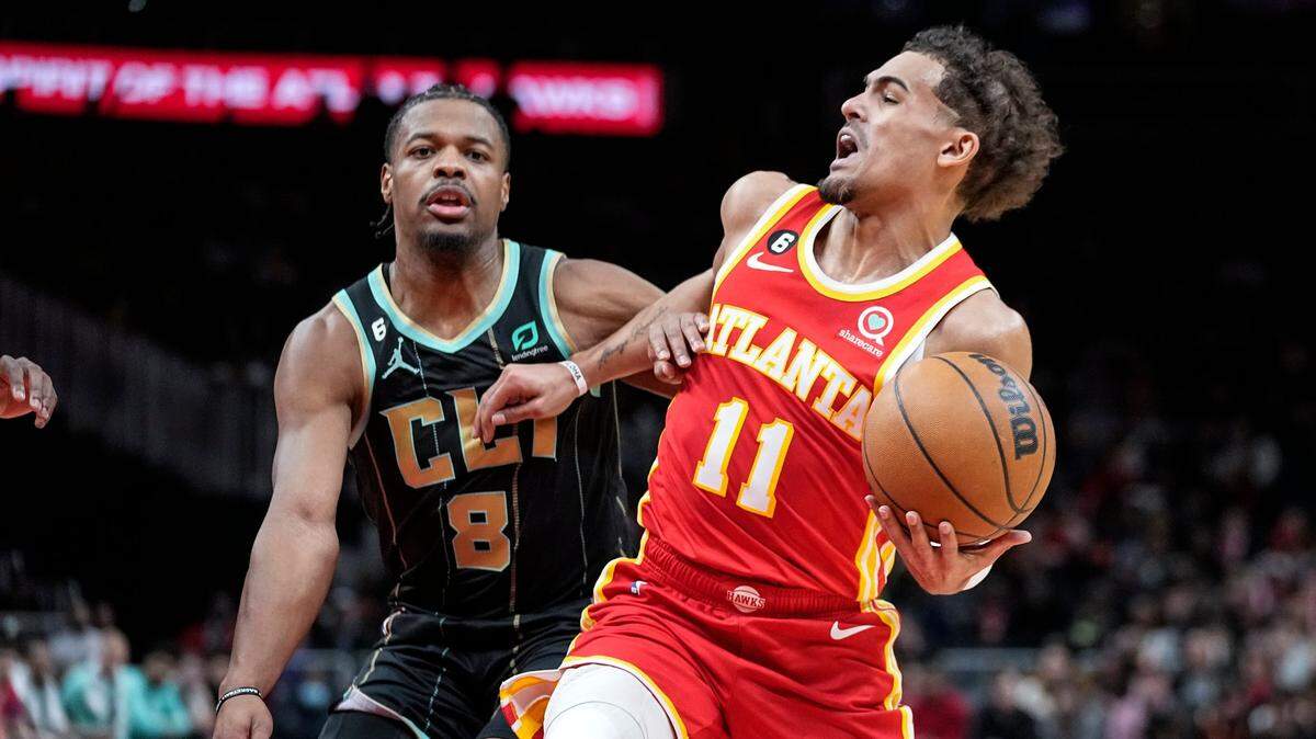 Atlanta Hawks guard Trae Young (11) is fouled by Charlotte Hornets guard Dennis Smith Jr. (8) during the first half of an NBA basketball game Saturday, Jan. 21, 2023, in Atlanta. (AP Photo/John Bazemore)