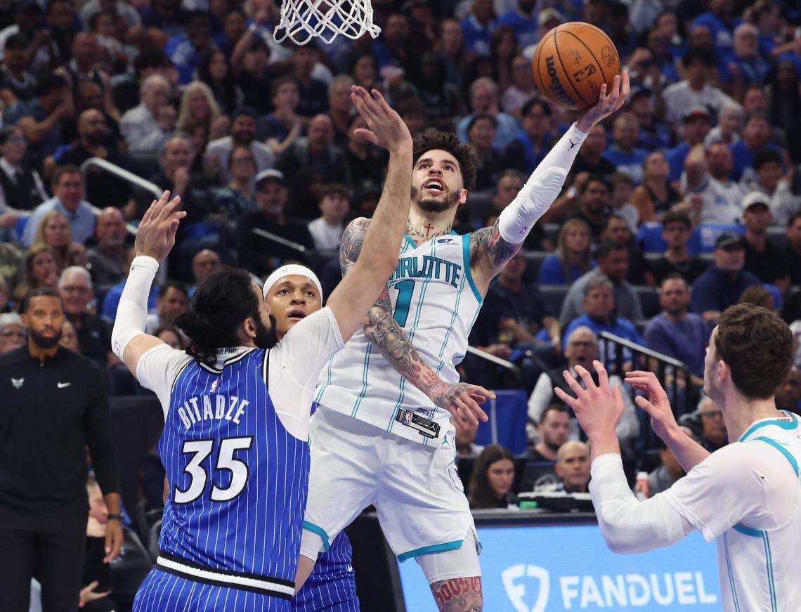 Charlotte Hornets guard LaMelo Ball, center, releases a one-handed a shot around Orlando Magic center Goga Bitadze, left, during action at Kia Center in Orlando, FL on Friday, April 17, 2026. The Magic defeated the Hornets 121-90.