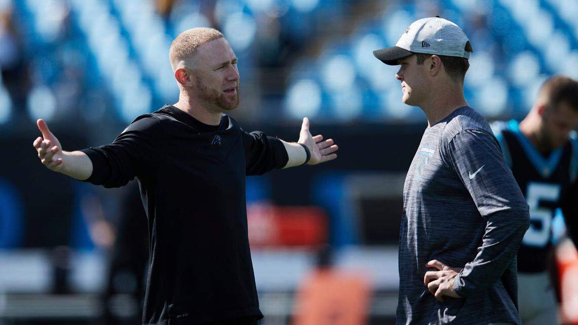 Carolina Panthers Offensive Coordinator Joe Brady (left) chats with quarterback Sam Darnold (14) prior to an NFL football game against the Minnesota Vikings, Sunday, Oct. 17, 2021, in Charlotte, N.C. (AP Photo/Brian Westerholt)