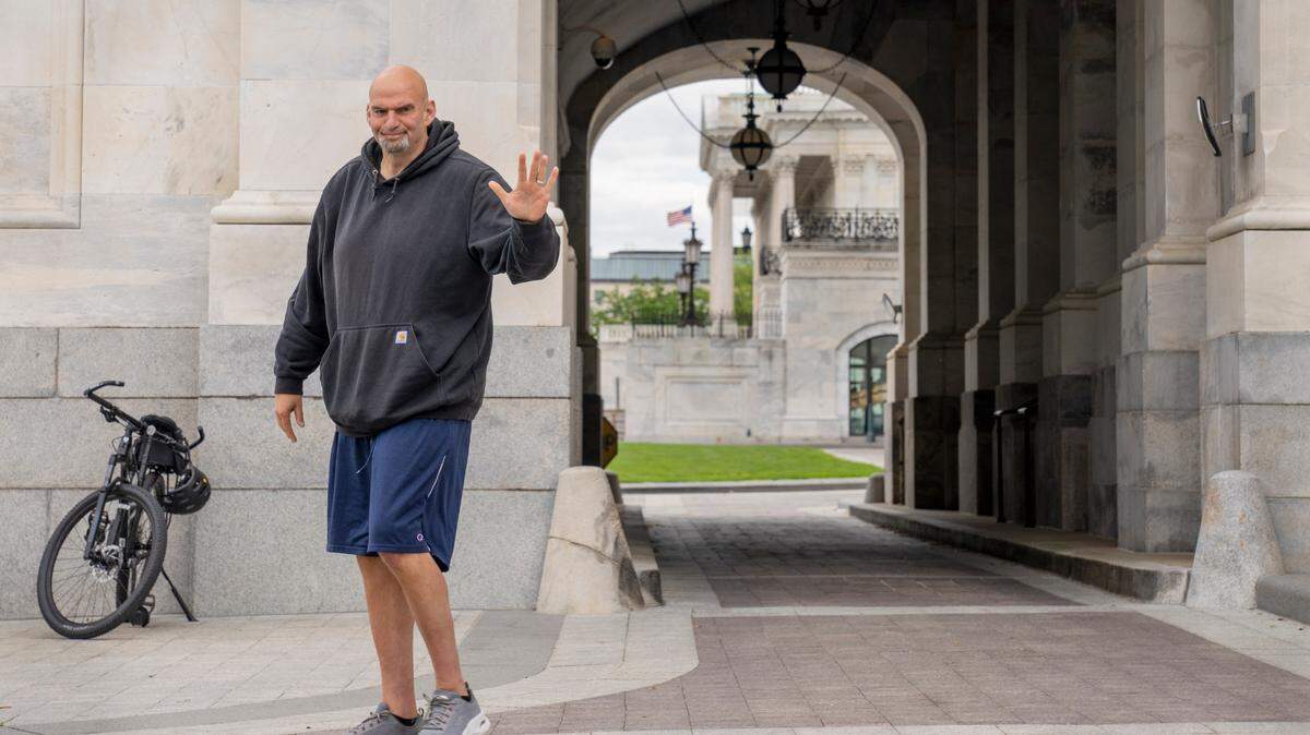 Sen. John Fetterman, D-Pa., waves to members of the media on April 17, 2023 on Capitol Hill in Washington. Fetterman’s signature hoodie and baggy shorts are no longer allowed under the U.S. Senate’s recently codified dress code.