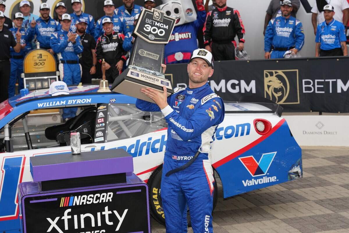 Concord, North Carolina, USA; William Byron (17) hoists the trophy after his win during the Bet MGM 300 at Charlotte Motor Speedway.