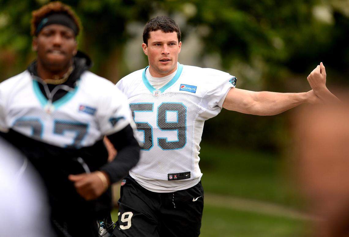 Carolina Panthers linebacker Luke Kuechly, center, bumps fists with fans as he jogs to practice on Tuesday. The Panthers started their minicamp on Tuesday morning, and while Kuechly can run through individual drills with teammates he can't fully practice yet.