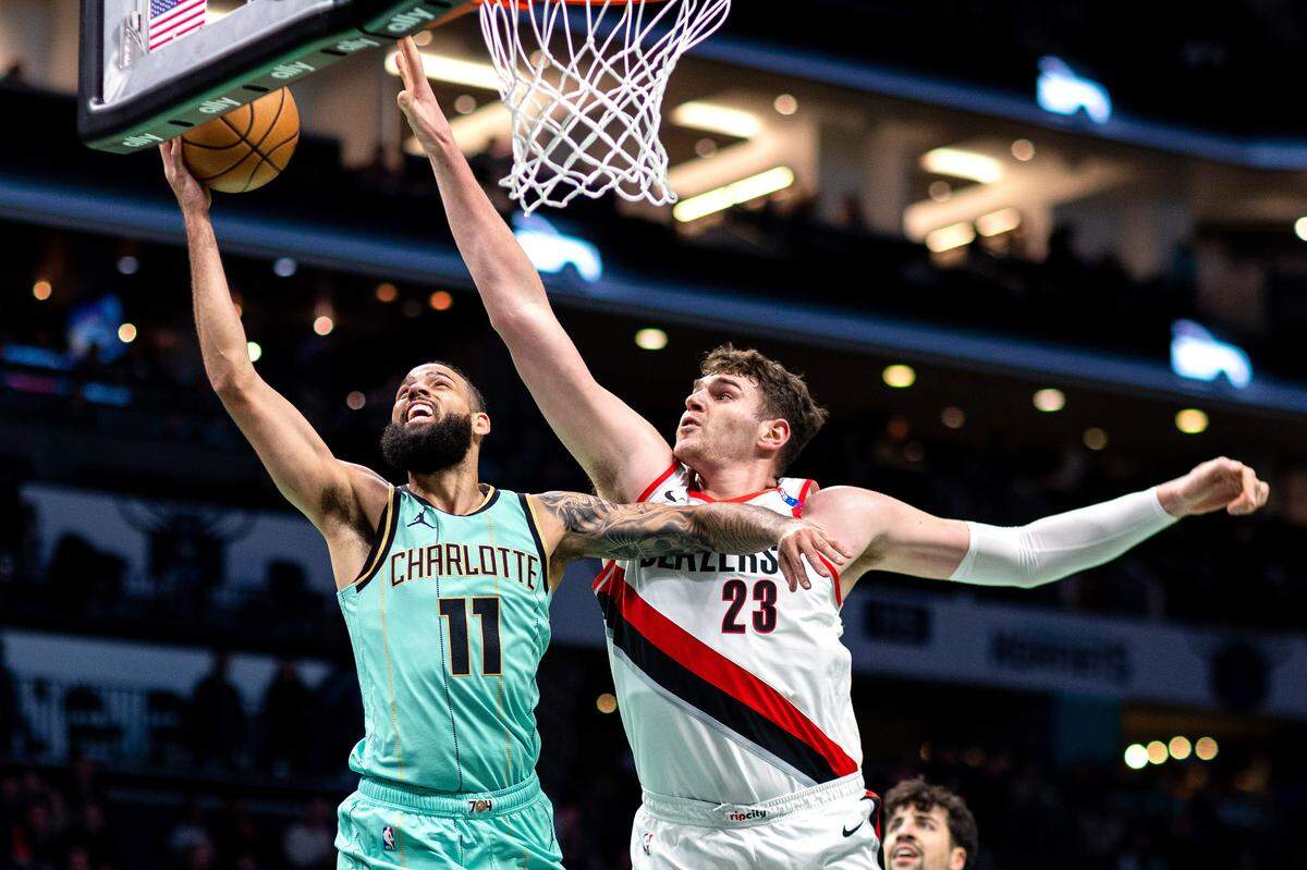 Charlotte Hornets forward Cody Martin (11) shoots around Portland Trail Blazers center Donovan Clingan (23) during the first quarter at Spectrum Center.