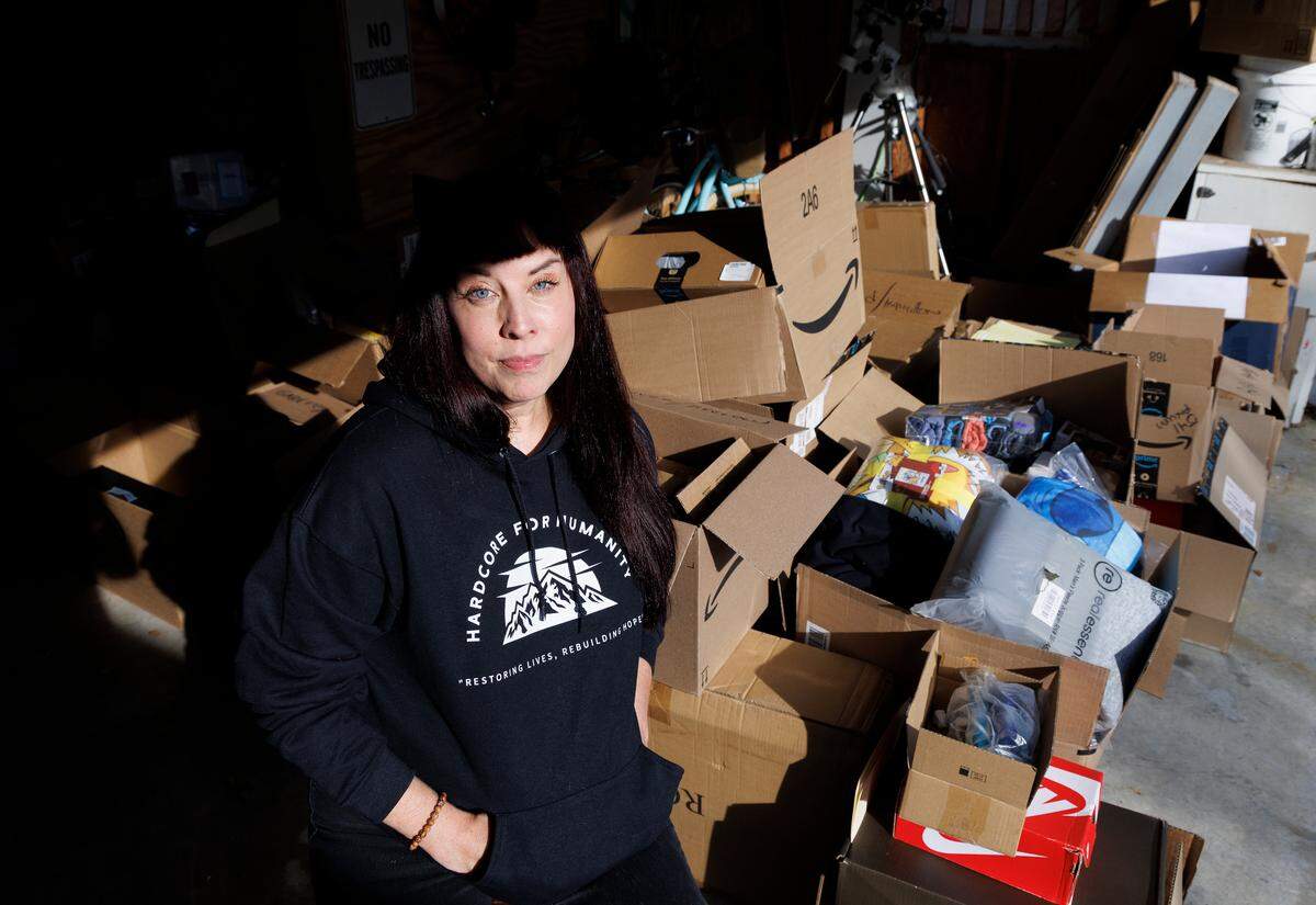 Dana Flaherty, who started a movement to get families impacted by the hurricane “adopted,” stands in a garage full of donations at her home in Willow Spring.