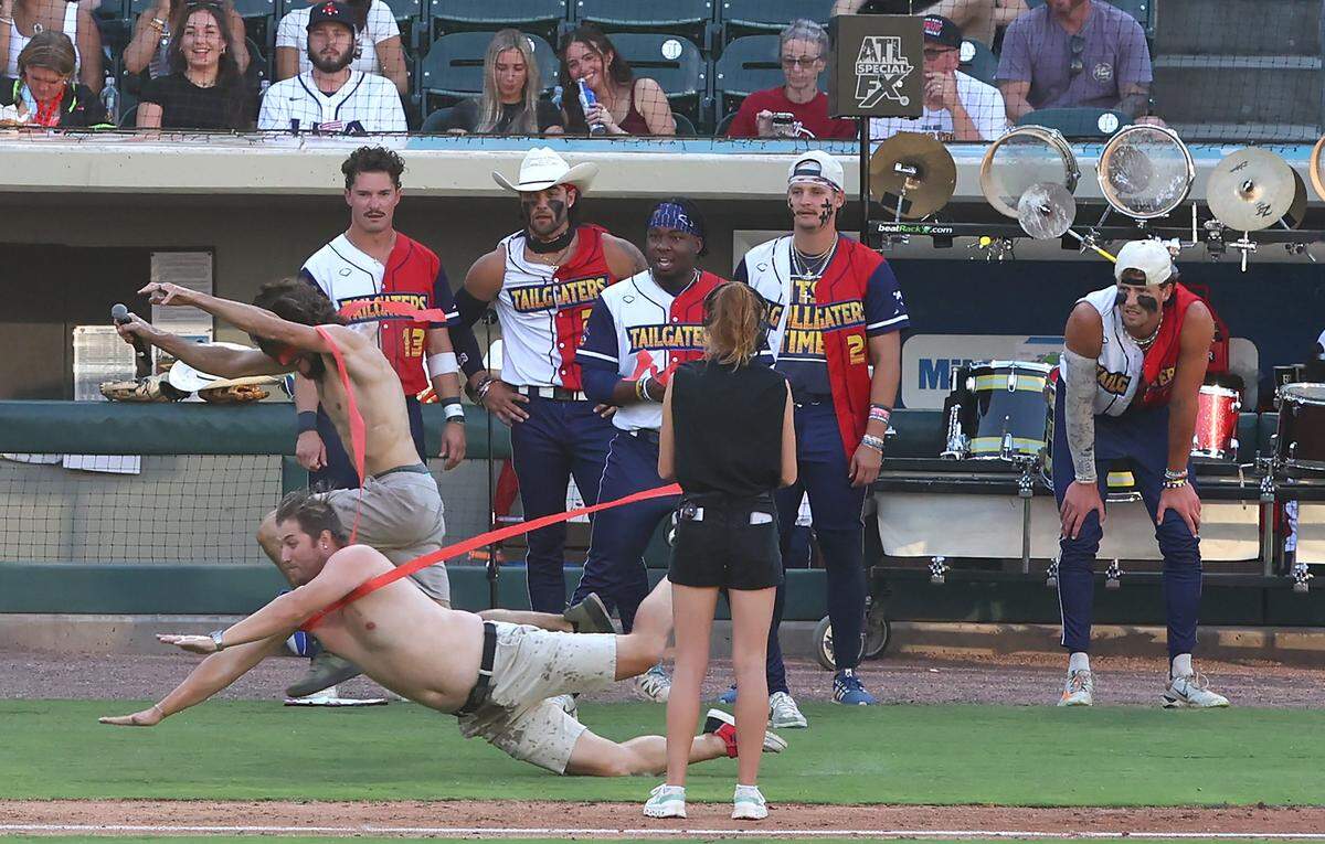 Fans dive for the finish line during a in game activity in the Texas Tailgaters vs Firefighters game at Truist Field in Charlotte, NC on Thursday, June 4, 2026. Banana Ball action returned to the Queen City with the Texas Tailgaters battling the Firefighters.