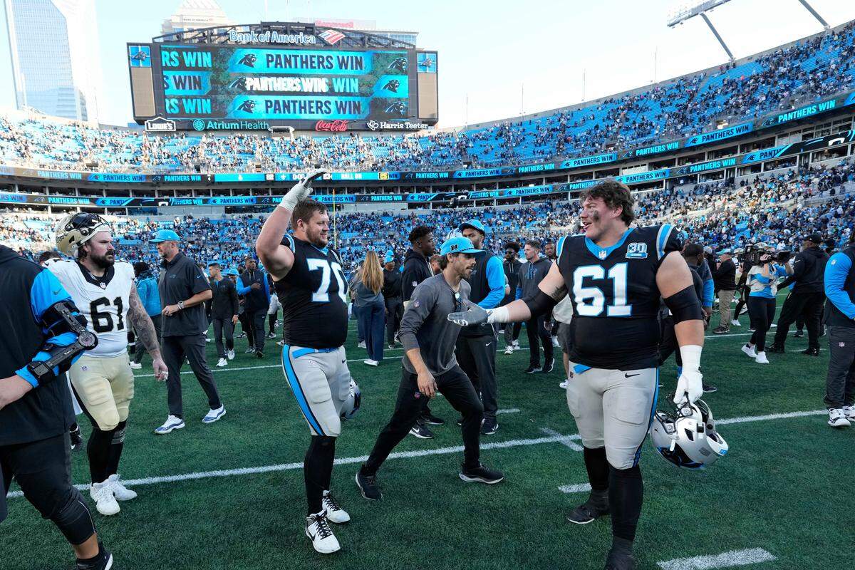 Nov 3, 2024; Charlotte, North Carolina, USA; Carolina Panthers guard Brady Christensen (70) and offensive tackle Jarrett Kingston (61) celebrate after the game at Bank of America Stadium. Mandatory Credit: Bob Donnan-Imagn Images