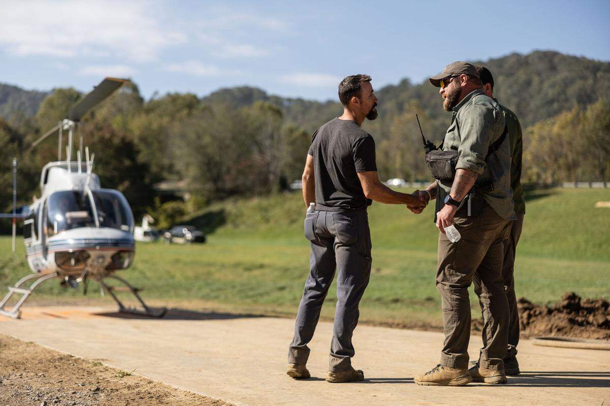 Adam Smith, right, shakes hands with a volunteer before boarding a helicopter at Savage Operations Center inside of a Harley Davidson store in Swannanoa, N.C. on Tuesday, October 8, 2024.