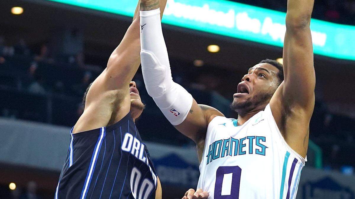 Charlotte Hornets forward Miles Bridges, right, releases a running one-handed shot over Orlando Magic forward Aaron Gordon, left, during first quarter action at Spectrum Center in Charlotte, NC on Monday, January 20, 2020.