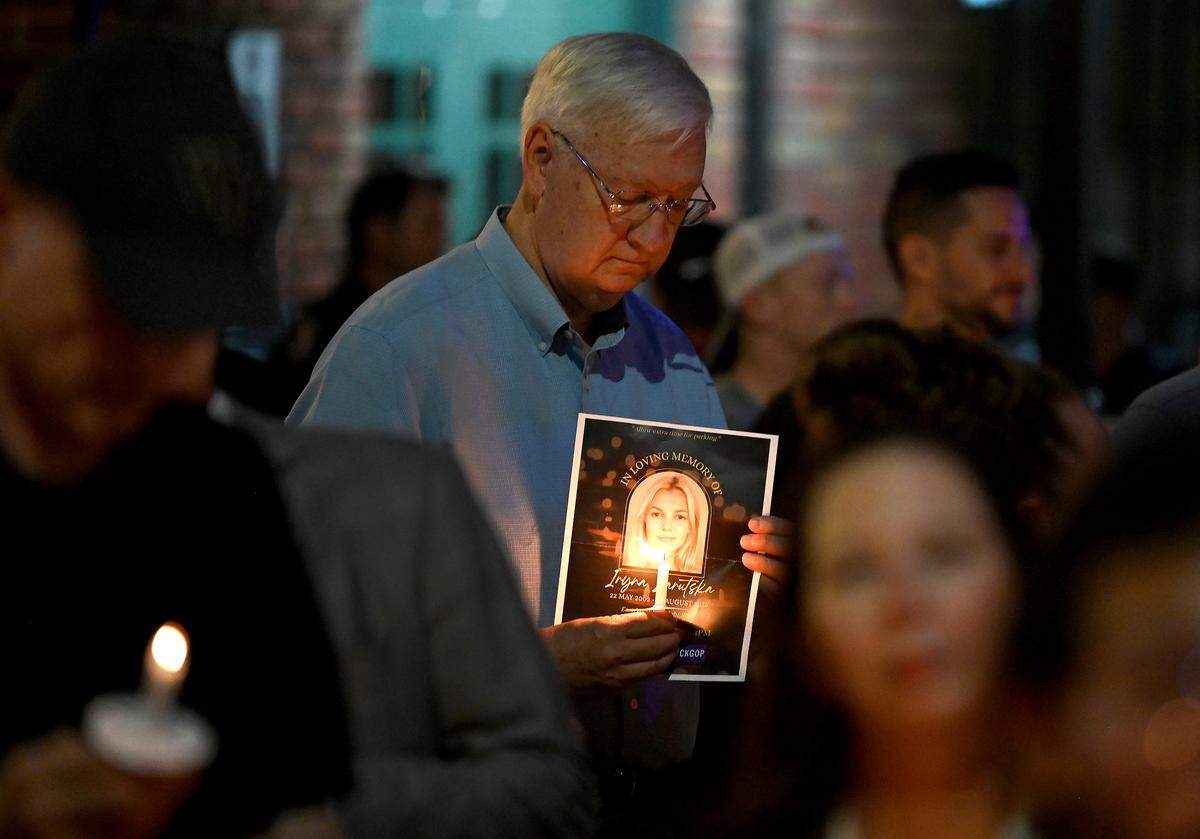 Tom Fuller of Charlotte holds a candle and a flyer with a photo of Iryna Zarutska during a memorial service for the 23-year-old Ukrainian refugee who was stabbed to death while riding the Charlotte Lynx Blue Line in August 2025.