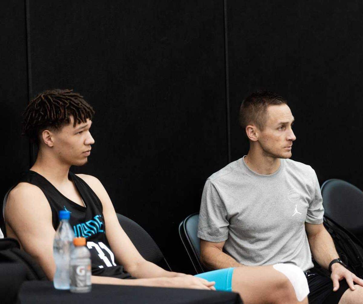 Charlotte Hornets vice president of player health and performance Trent Salo takes in some practice action while sitting next to rookie Tidjane Salaün.