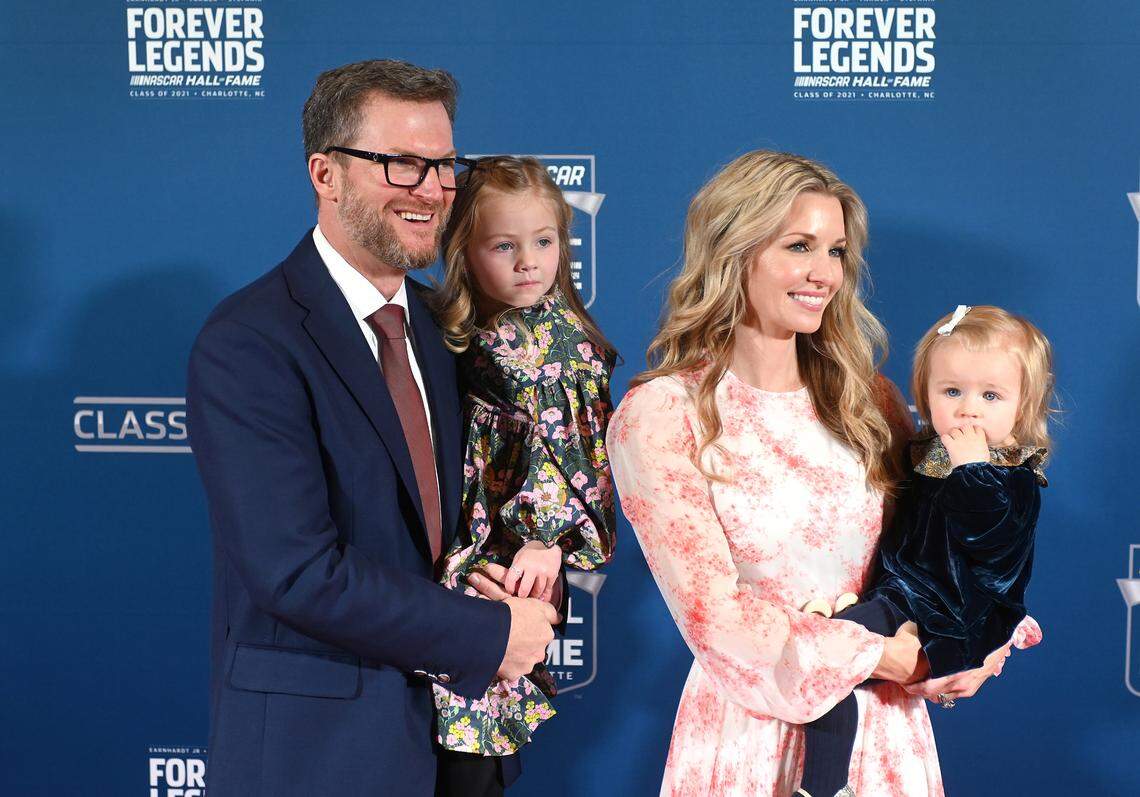 Dale Earnhardt Jr., left, waves at onlookers along the red carpet with daughters Isla and Nicole and wife, Amy Earnhardt. Earnhardt Jr. was inducted into the NASCAR Hall of Fame on Friday, January 21, 2022.