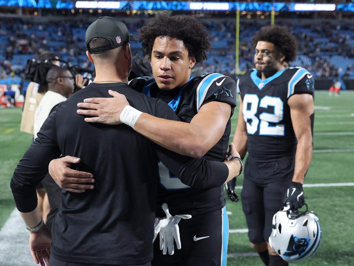 Carolina Panthers head coach Dave Canales, left, hugs wide receiver Jalen Coker, right, following the teams 34-31 loss to the Los Angeles Rams at Bank of America Stadium on Saturday, January 10, 2026.