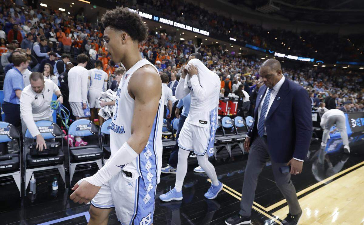 North Carolina's Seth Trimble (7), Elijah Davis and head coach Hubert Davis walk off the court after VCU’s 82-78 overtime victory over UNC in the first round of the NCAA Tournament Thursday. 