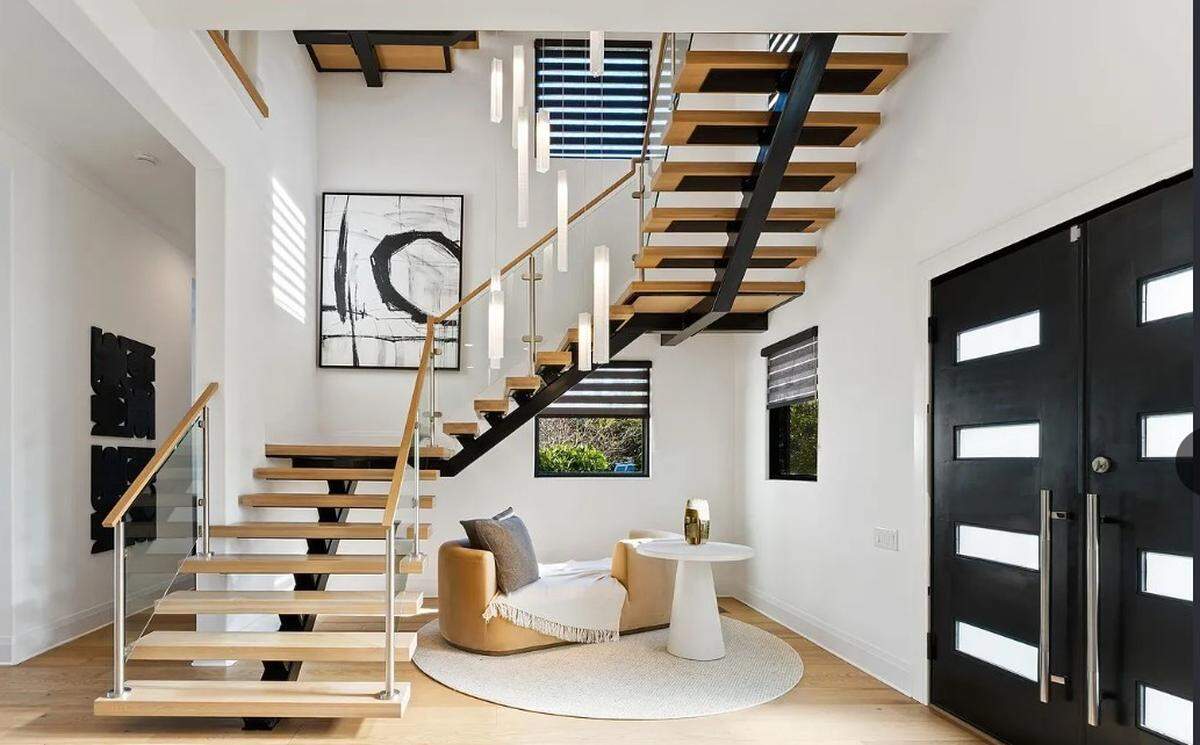 A 30-foot, handmade chandelier weaves through a sculptural staircase in the mansion.