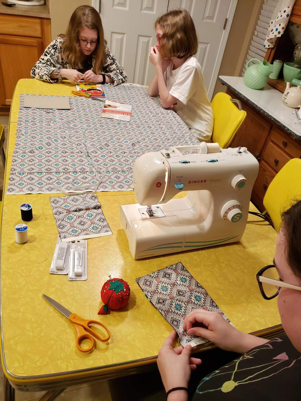 The Nichols family has started an assembly line for mask-making at their kitchen table to aid hospitals short on supplies amid the coronavirus pandemic. The family’s oldest daughter, Marina, 15, sews the masks, while her mother, Kim, and 12-year-old sisters, Tessa and Savannah, cut the material.