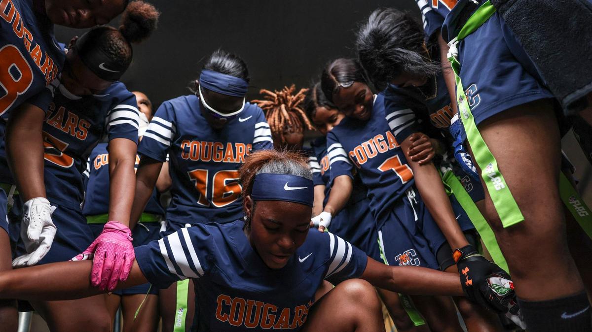 Chambers players say a prayer together before the first flag football championship game against Butler at the Bank of America Stadium in Charlotte, N.C., on Sunday, May 15, 2022.