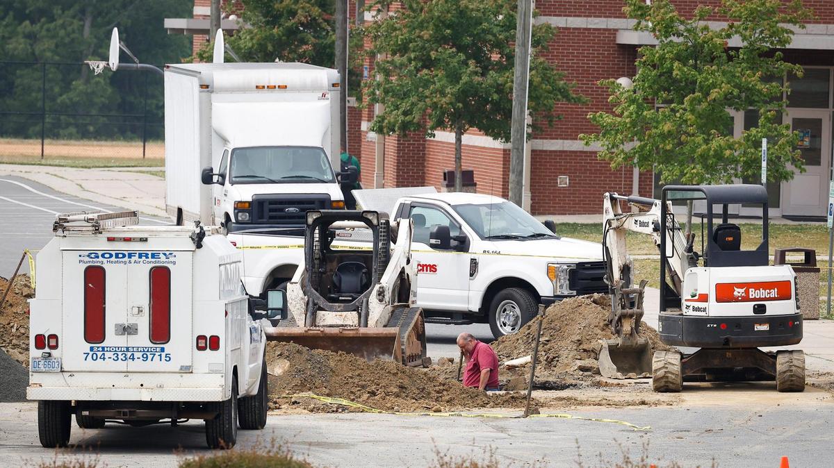 Work continues in the parking lot following reports of a water line break at Whitewater Academy in Charlotte, N.C., Friday, May 6, 2022.