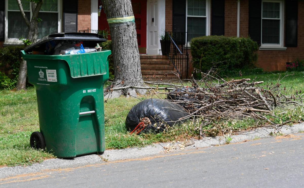 Yard waste is stacked beside a recycling bin during pickup day in Charlotte on Tuesday, April 7, 2020.Yes, yard waste pick up has been delayed during the COVID-19 pandemic. But take the waste to a Mecklenburg County recycling center only if you consider it essential to do so, and wear gloves and masks that follow the Public Health and CDC guidelines, county officials said.