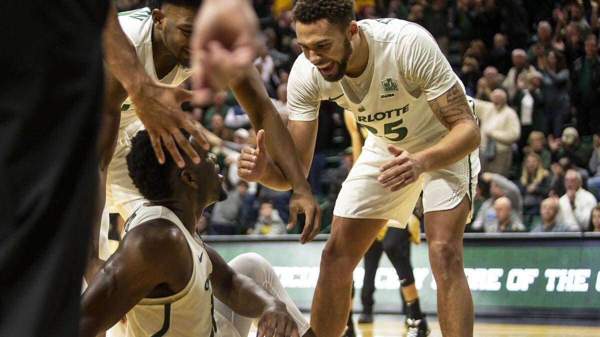 Charlotte’s Drew Edwards (25) smiles and helps up teammate Amidou Bamba after blocking a shot against Wake Forest in overtime at Halton Arena in November. Edwards, a transfer from Providence, is the 49ers’ third-leading scorer this season.
