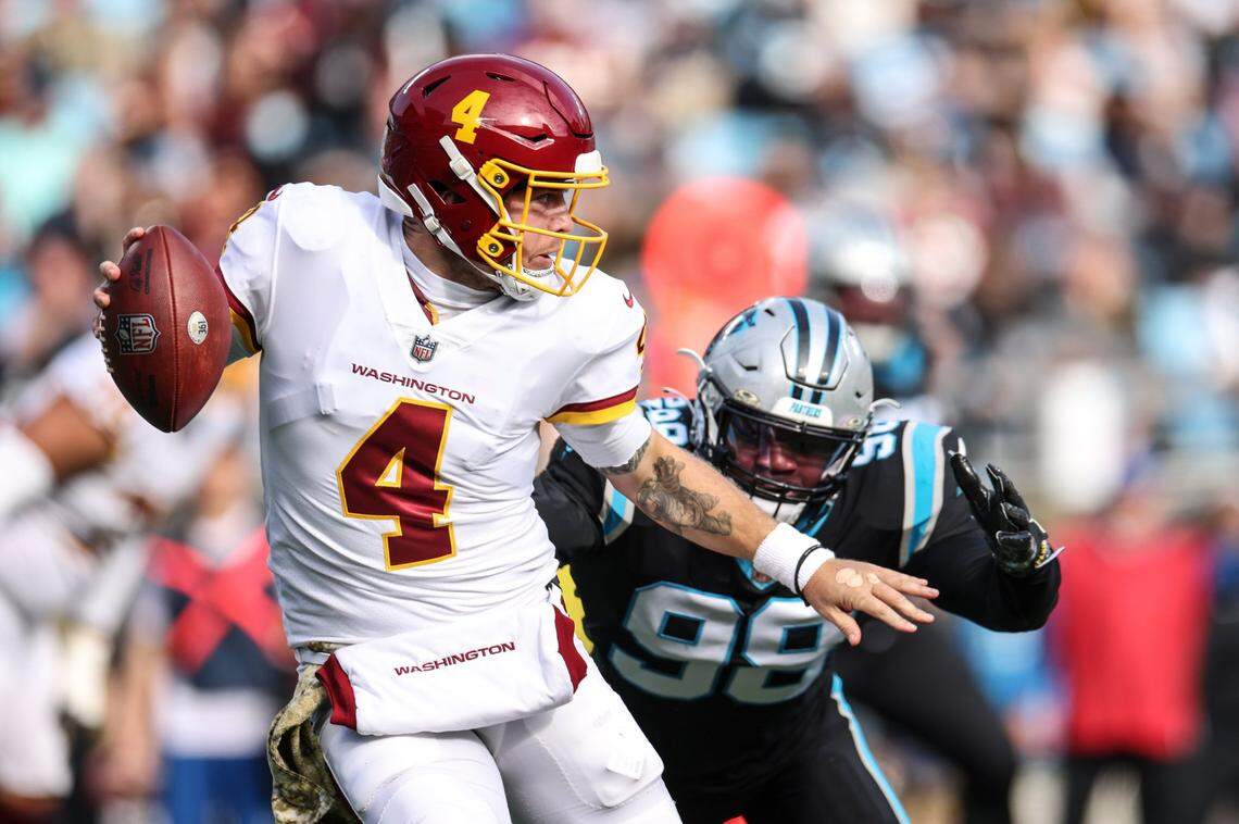 Washington Football Team Taylor Heinicke, left, is sacked by Carolina Panthers Marquis Haynes Sr. at the Bank of America Stadium in Charlotte, N.C., on Sunday, November 21, 2021.