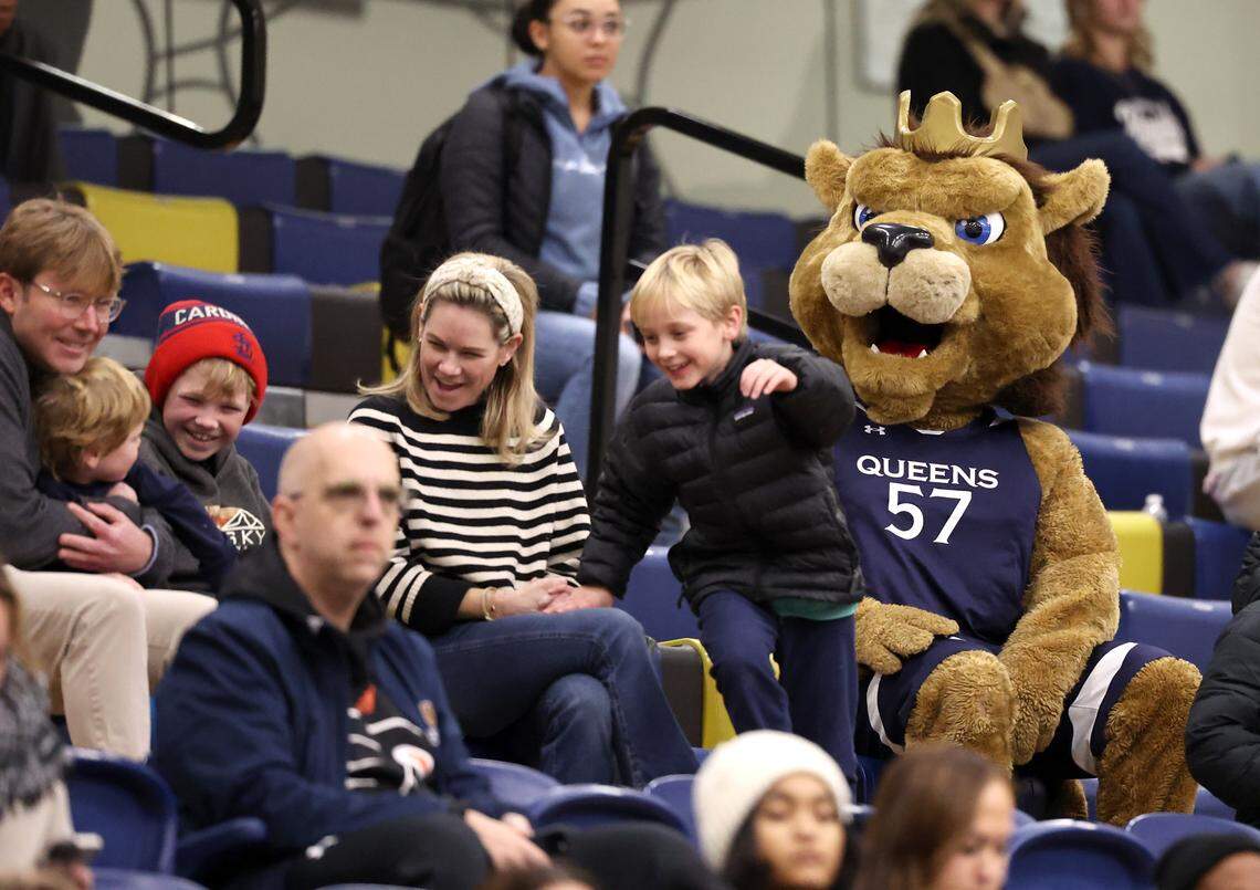 Children run away from Queens University of Charlotte Royals mascot Rex, right, as he attempts to make friends in the stands during the team’s game against the North Florida Ospreys on Thursday, January 23, 2025 at Curry Arena in Charlotte, NC. The Ospreys defeated Queens University 90-81.