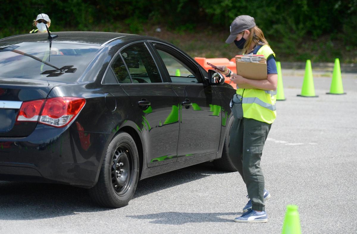 Assistant Health Director Brittain Kenney of Gaston County Public Health help to process a driver coming to get his second shoot at the vaccination site at Eastridge Mall on Wednesday, April 28, 2021. Kenney is the unofficial vaccine coordinator on vax clinic days, racing to businesses at the Eastridge Mall in Gastonia to ensure no doses are wasted. Demand has decreased noticeably. On this day, no vaccines were left over.