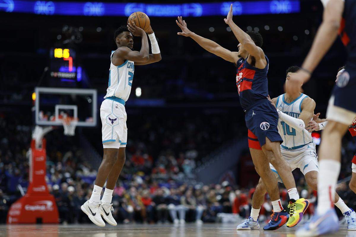 Charlotte Hornets forward Brandon Miller (24) shoots the ball aa Washington Wizards guard Malcolm Brogdon (15) defends in the second quarter at Capital One Arena.