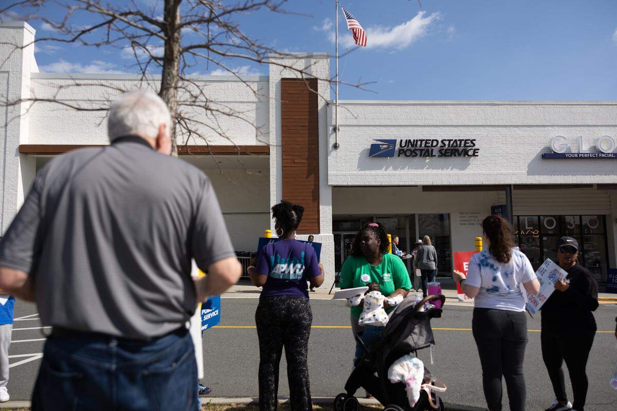 Protesters gather on the sidewalk during the “US Mail Not For Sale” rally outside of the USPS Park Road office in Charlotte on Thursday, March 20, 2025.