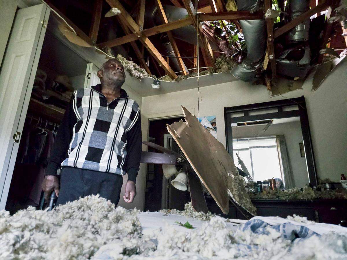 McKinley Moore inspects the damage on his home after a tree fell over his bedroom early Friday morning Sept. 27, 2024 in Charlotte. The ceiling fan and along with the ceiling fell on top of him.
