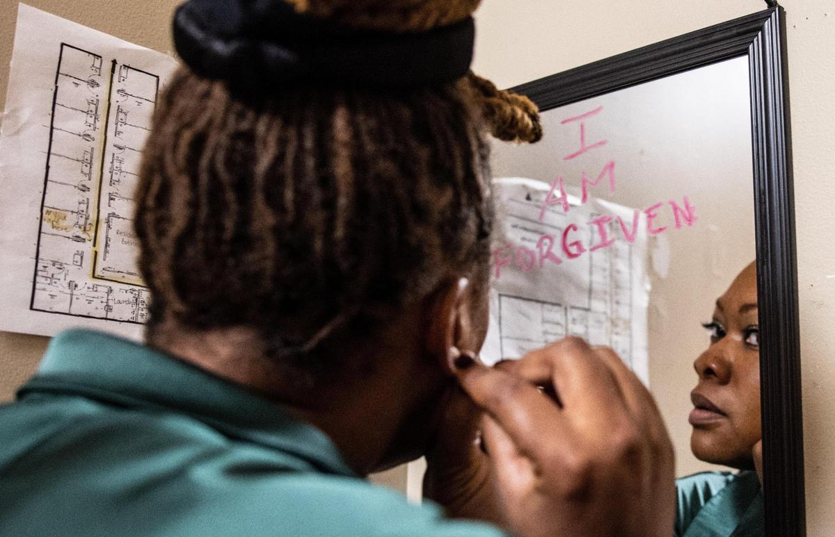 Shaheedah Martin, at the Center for Community Transitions in Charlotte, puts on her earrings before her first day of work on Friday, July 2, 2021.