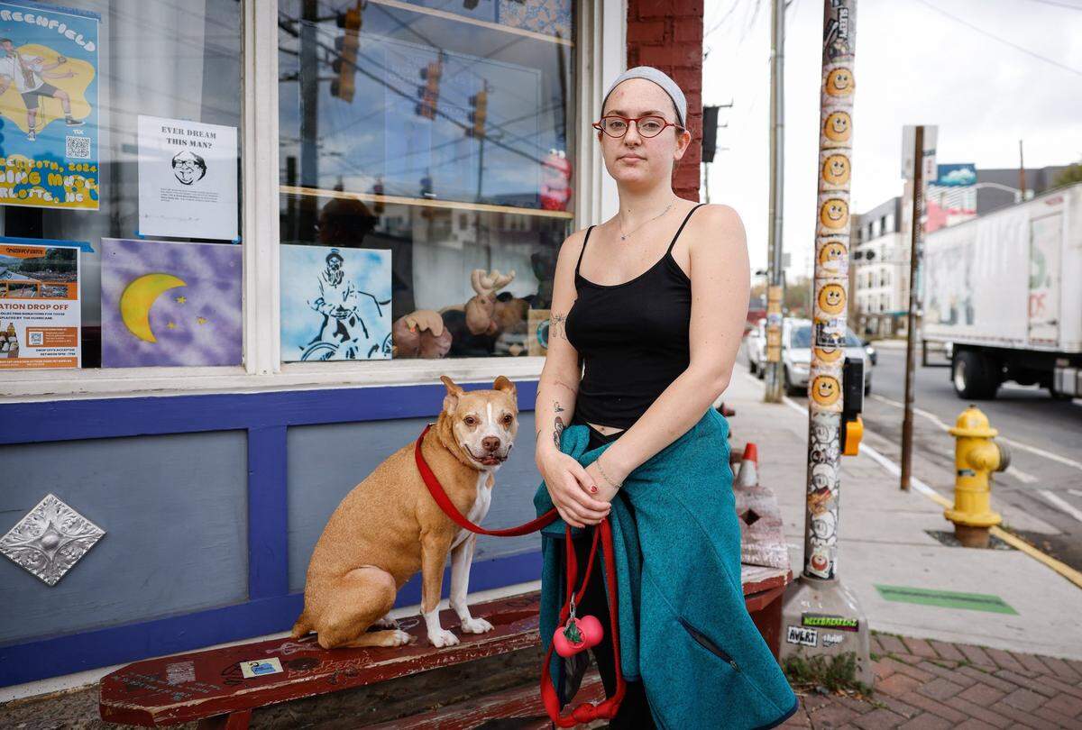 Sophia Parker and her dog, Bella, says “I feel very disappointed, very heartbroken and scared; very scared” outside Evening Muse in the NODA neighborhood in Charlotte, NC on Wednesday, November 6, 2024.