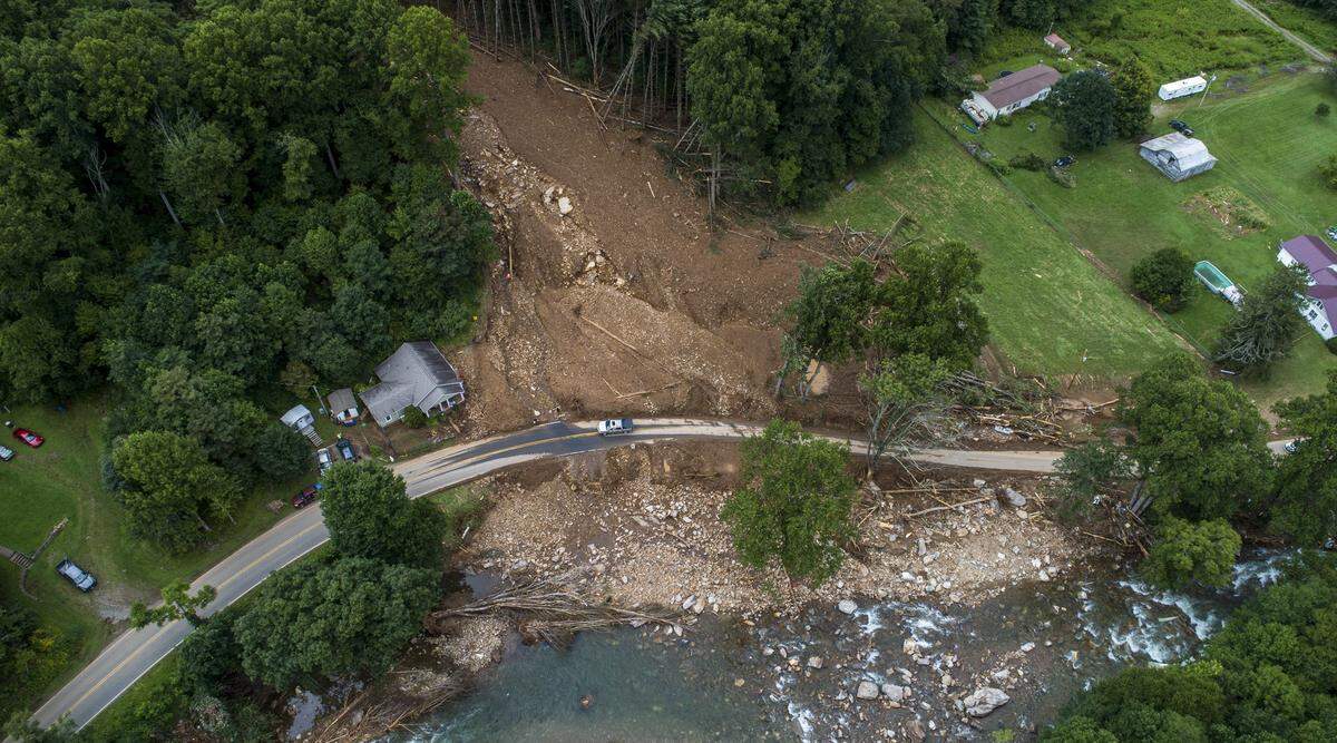 A landslide spills into the East Fork Pigeon River in Cruso Friday, Aug. 20, 2021 after remnants from Tropical Storm Fred caused flooding in parts of Western North Carolina Tuesday. Five people are missing and at least four people were found dead.