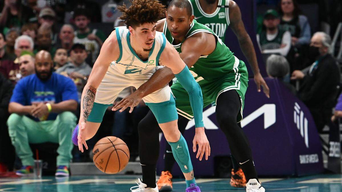 Charlotte Hornets guard LaMelo Ball, left, attempts to maintain control of the ball as Boston Celtics forward Al Horford, right, applies defensive pressure during first half action at Spectrum Center in Charlotte, NC on Wednesday, March 9, 2022.