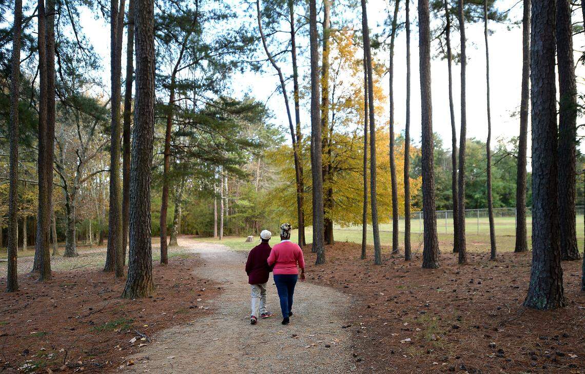 Chancellor Lee Adams, left and his grandmother Saundra Adams, right, walk down a path at Reedy Creek Park in Charlotte, NC on Tuesday, November 10, 2020. Chancellor Lee will celebrate his 21st birthday on Monday, November 16, 2020.
