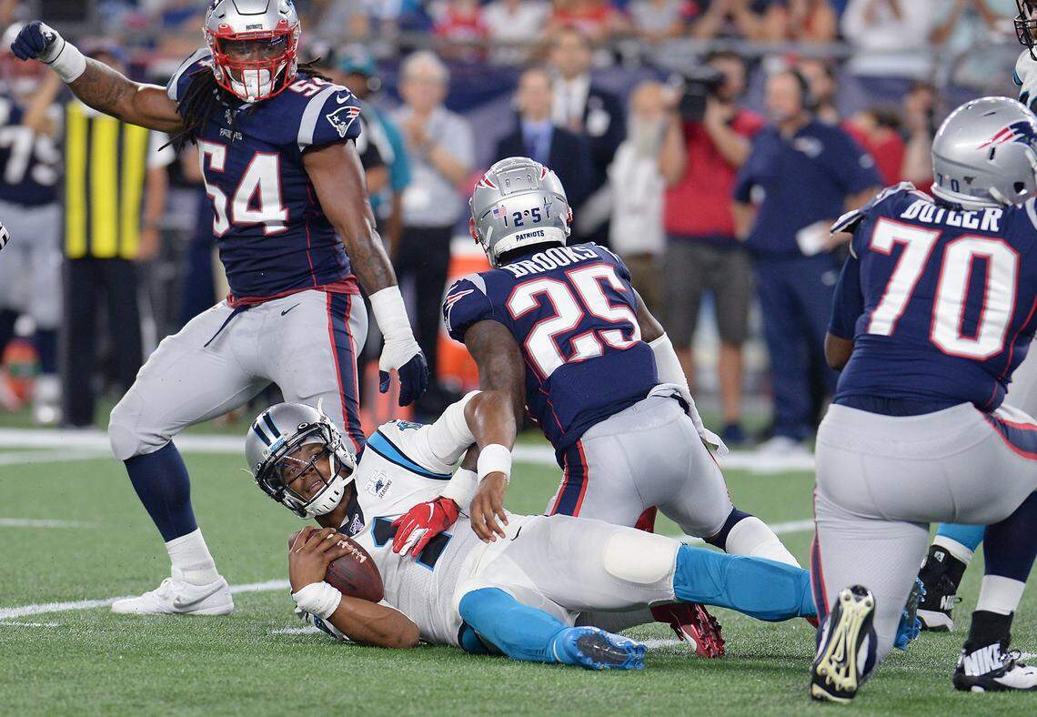 Carolina Panthers quarterback Cam Newton lays on the turf after being sacked New England defensive lineman Adam Butler (70) during the first quarter Thursday night. Newton didn’t return in Carolina’s 10-3 loss and left the stadium in a walking boot.