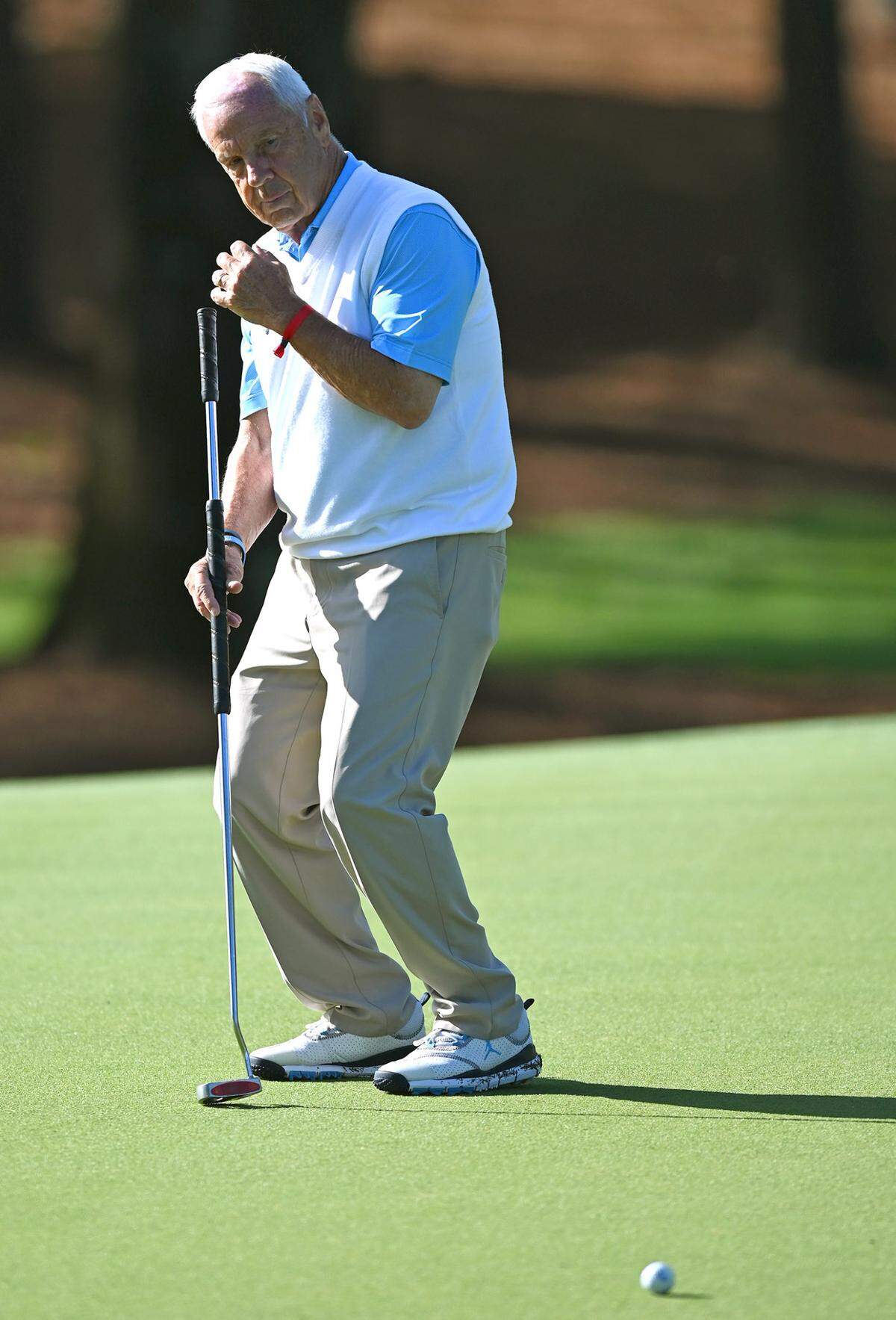 Former UNC head basketball coach Roy Williams reacts to a missed putt Wednesday.