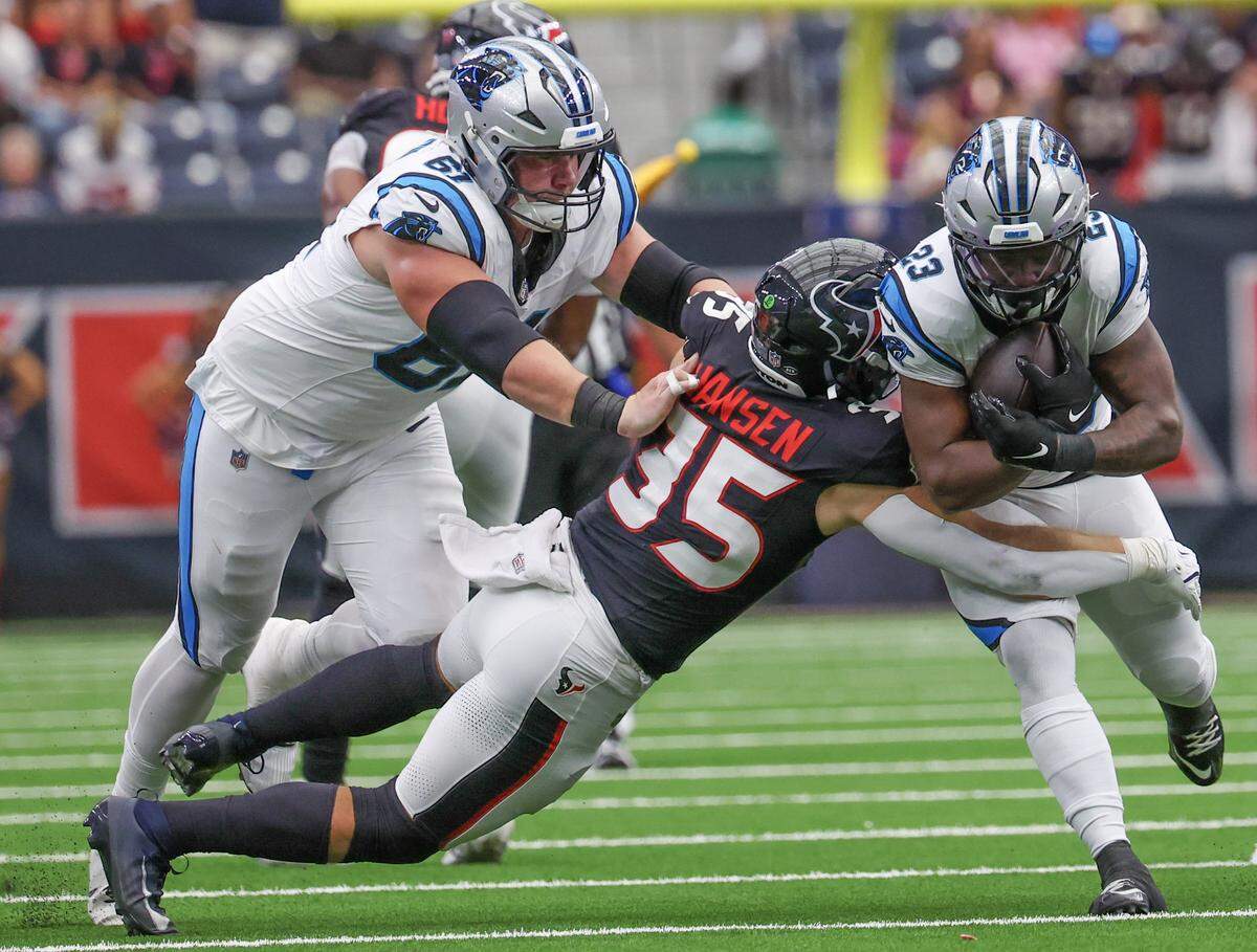Aug 16, 2025; Houston, Texas, USA; Carolina Panthers running back Trevor Etienne (23) is tackled by Houston Texans linebacker Jake Hansen (35) in the second quarter at NRG Stadium.