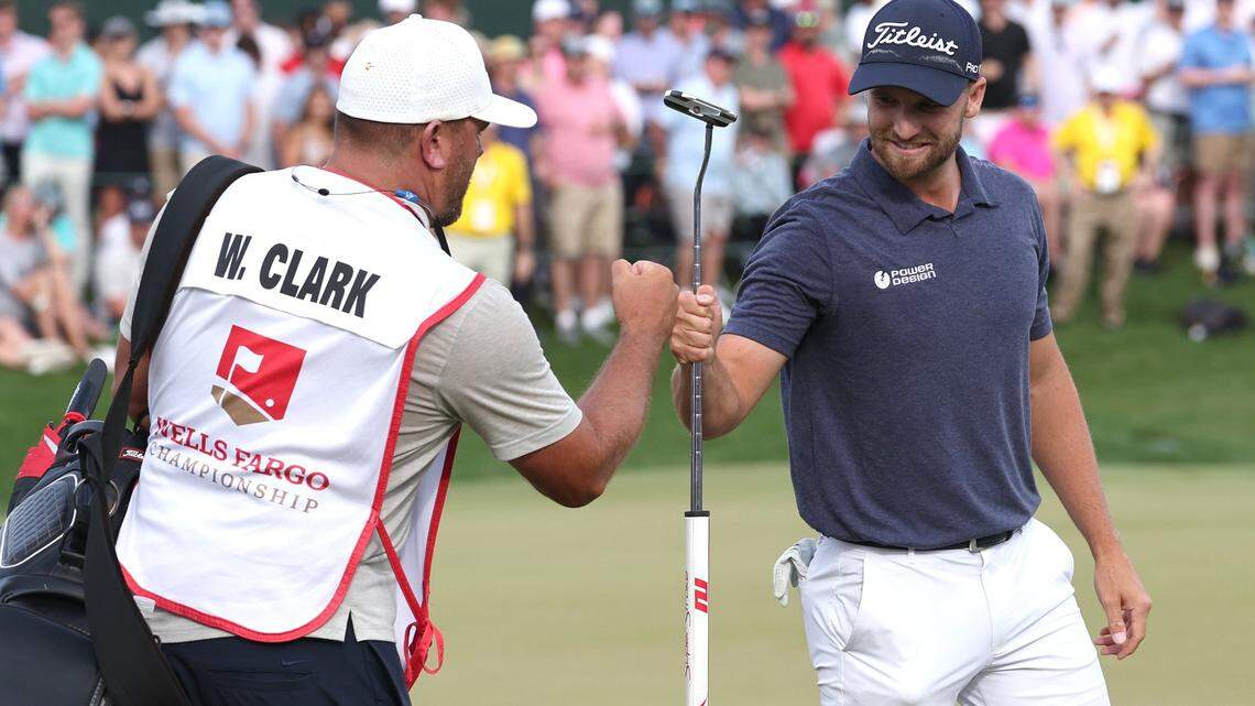 Wyndham Clark, right, bumps fist with his caddie, left, after sinking the winning putt at the Wells Fargo Championship on Sunday at Quail Hollow Club. Clark finished at 19-under for the tournament.