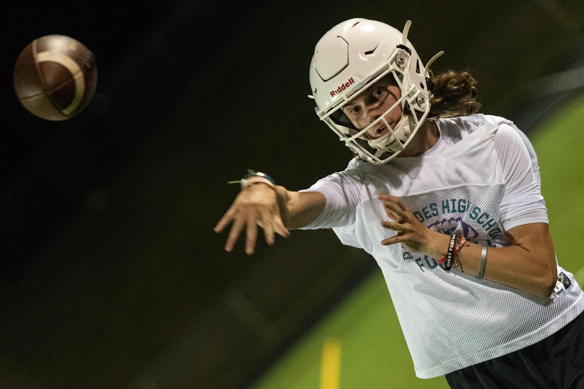 Sixteen-year-old quarterback Jarek Patulski warms up his arm as the Palisades High School Pumas hold the first season practice with coach Jonathan Simmons at Palisades High School in Charlotte, N.C. just after midnight on Aug. 1, 2022.